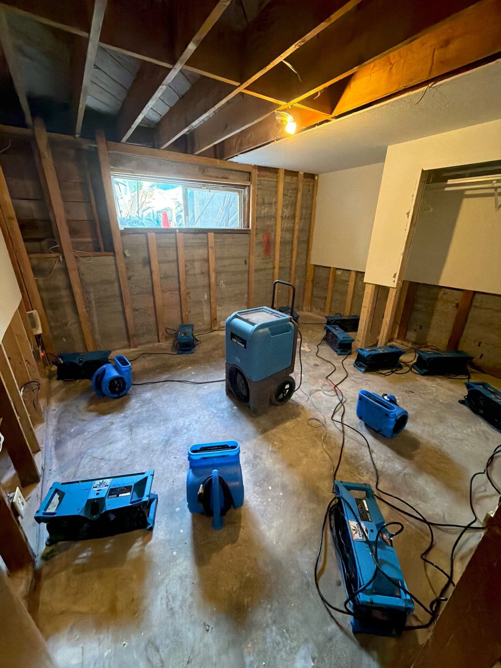 Restoration technician in protective equipment cleaning smoke damage inside a home